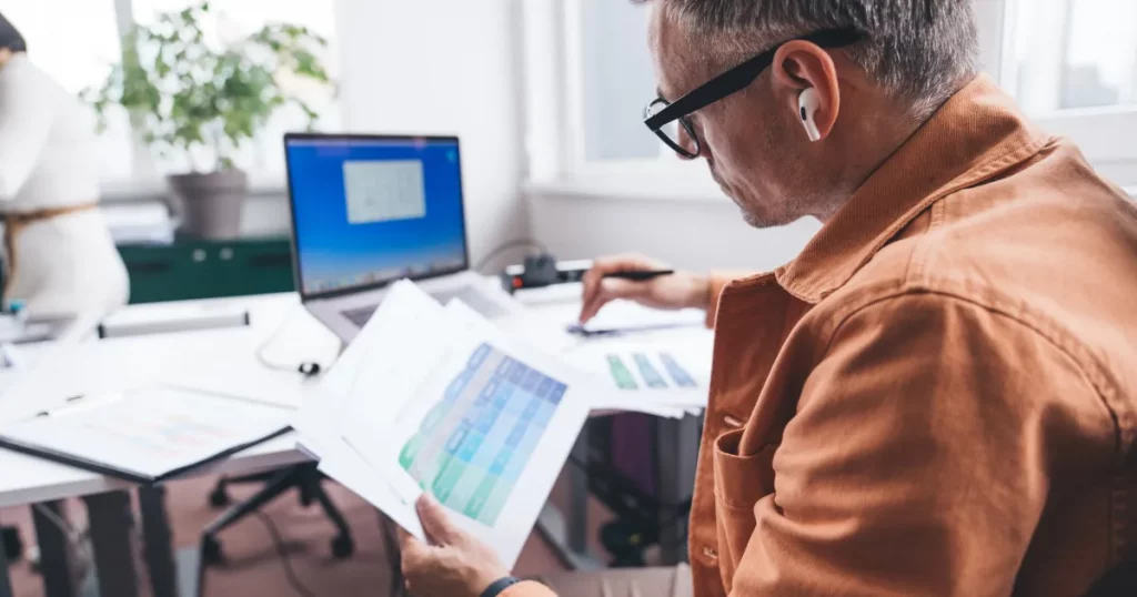 Analyst reviewing printed data reports at an office desk